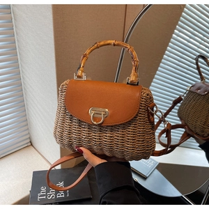 Close-up of woven straw handbag with a bamboo handle and retro vintage metal buckle