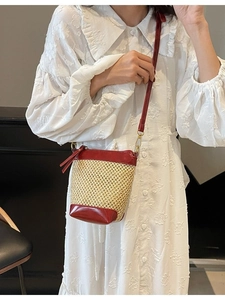 Handmade straw bucket bag with red leather trim and shoulder strap for beach vacation