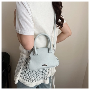 Side view of light blue shell bag in lychee texture leather with crossbody strap