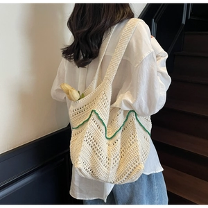 Detail of handmade crochet tote bag with green wavy trim and natural tulip decoration