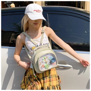 Detail of light green ITA bag with transparent front pocket showing custom badges