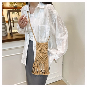 Detailed view of bohemian hand-woven cotton phone bag featuring diamond patterns and long tassels