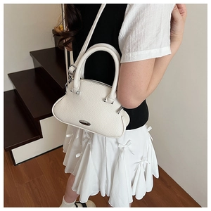 Detail of white lychee-patterned shell bag with silver hardware and leather handles
