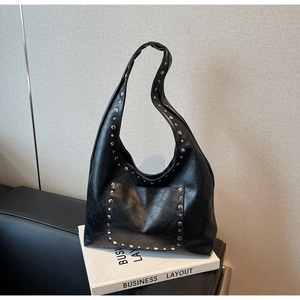 Détail d'un sac hobo en cuir PU noir avec rivets métalliques argentés et poche extérieure