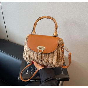 Detail of woven straw handbag featuring vintage bamboo handle and leather flap with gold lock