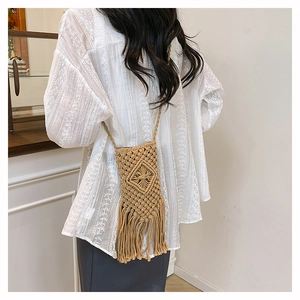 Detail of bohemian macrame woven phone bag featuring elegant long tassels and diamond pattern