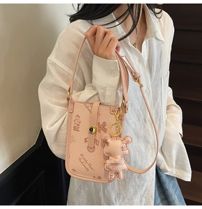 Pink PU leather crossbody phone bag with teddy bear charm and logo print on adjustable strap