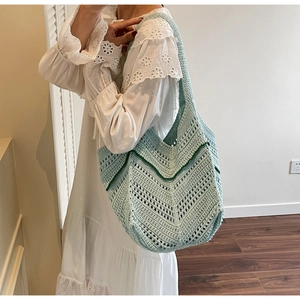 Detail of mint green crochet tote bag featuring intricate openwork knit pattern