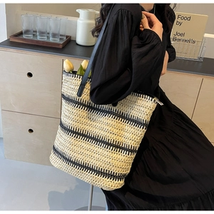 Vue détaillée d'un grand sac cabas tissé avec rayures noires et lanières en cuir