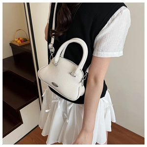 Detailed shot of white lychee texture shell bag with silver logo and dual handles