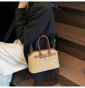 Detail of woven straw handbag featuring brown leather trim and silver metal lock closure