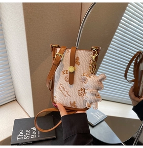Detail of mini crossbody bag with cartoon bear print and adjustable brown shoulder strap