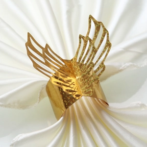Close-up of golden laser-cut butterfly napkin ring with hollow-out wing details