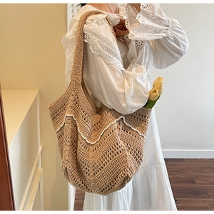 Detail of hand-woven hollow tote bag with white lace V-shaped trim on a model