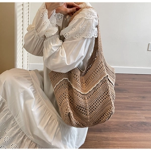 Close-up of handmade crochet hollow tote bag with white wavy trim and woven texture