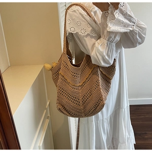 Detailed close-up of bohemian hollow crochet shoulder bag with wave texture edges