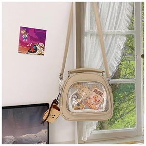 Detail of beige ITA bag with clear PVC window showcasing cute plush and card accessories