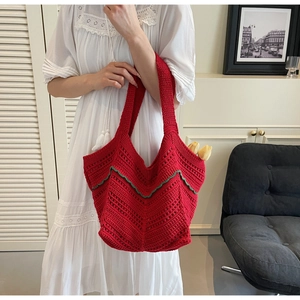 Macro detail of red crochet tote bag featuring intricate woven texture and green scalloped edges