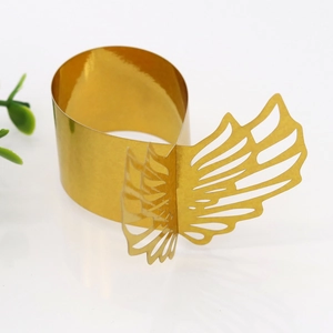 Detailed macro view of golden laser-cut butterfly napkin ring with hollow wing patterns