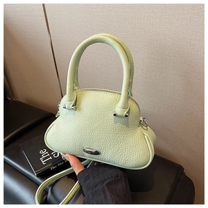 Close-up of mint green shell bag featuring lychee grain leather and silver metal plate