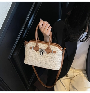 Detail of woven straw handbag featuring brown leather trim and metallic padlock clasp