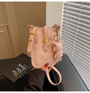 Pink lychee leather crossbody phone bag featuring a bear print and a cute plush charm