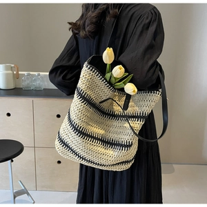 Gros plan du sac cabas tissé avec rayures noires et bandoulières élégantes en similicuir