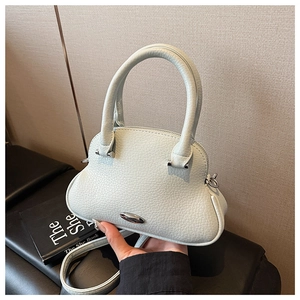 Detail of mint green lychee pattern leather handbag with silver oval buckle and handle