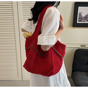 Detailed close-up of handmade red crochet tote bag with green wavy edge and hollow texture