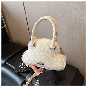 Detail of white lychee-patterned mini shell bag with silver hardware and top handles