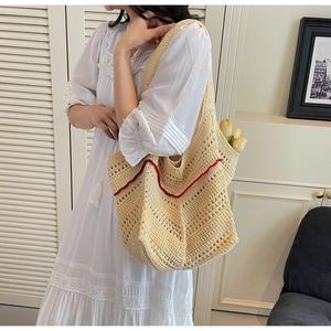 Detailed close-up of beige handmade crochet tote bag with red wavy stripe pattern