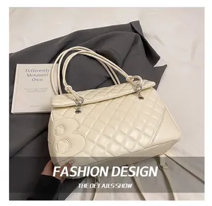 Dettaglio della pelle trapuntata beige e dell'iconico logo B in metallo sulla borsa a spalla