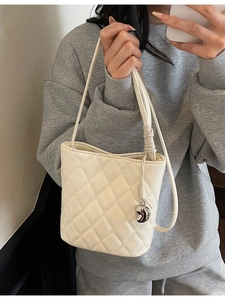 Elegante borsa a secchiello trapuntata crema con ciondolo a luna e tracolla fine