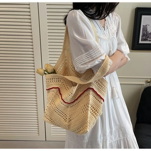 Detailed close-up of handmade crochet tote bag with geometric patterns and red trim