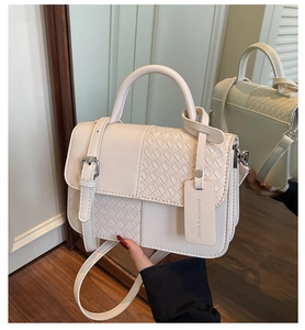 Detail of beige woven patchwork handbag with mirror reflection and fashion hangtag