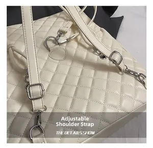 Dettaglio borsa trapuntata in pelle crema con tracolla regolabile e fibbie metalliche