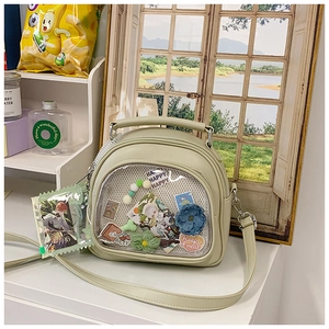 Close-up of light green Ita-bag with clear PVC window and plush flower decoration