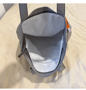 Vue détaillée du grand espace intérieur avec poche zippée et doublure blanche du sac en nylon