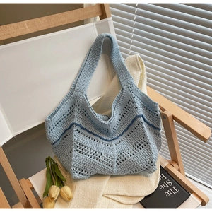 Detail of light blue hand-woven crochet tote bag with hollow knit pattern and wavy trim
