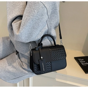 Black leather crossbody bag featuring woven patchwork textures and fashion tag detail