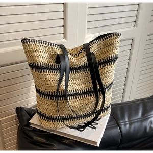 Détail de la texture tissée et des anses en cuir noir sur ce sac cabas à rayures