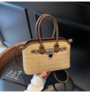 Close-up of woven straw handbag featuring brown leather trim and metallic lock detail