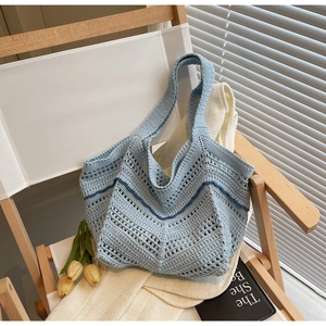Detailed close-up of light blue hand-woven crochet tote bag with hollow geometric patterns