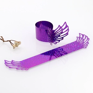 Close-up of laser-cut holographic purple paper napkin rings with angel wing pattern