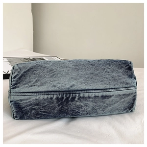Detailed view of the rectangular stitched base on a vintage wash blue denim tote bag