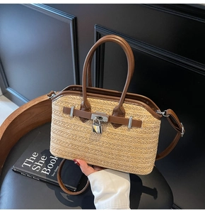 Close-up of woven straw handbag with brown leather trim and silver metal padlock detail