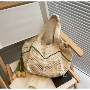Close-up of cream crochet tote bag with hollow-out texture and green wave-edge detailing