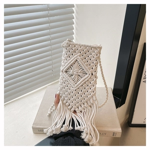 Close-up of beige macrame woven shoulder bag with boho tassels and geometric patterns