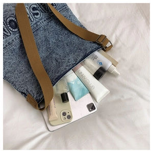 Internal view showing large capacity of blue acid-wash denim tote with daily essentials