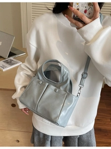 Minimalist light blue leather tote bag with front pockets for daily urban commuting